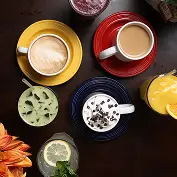 A variety of colorful cups and saucers with different beverages and desserts on a dark table.